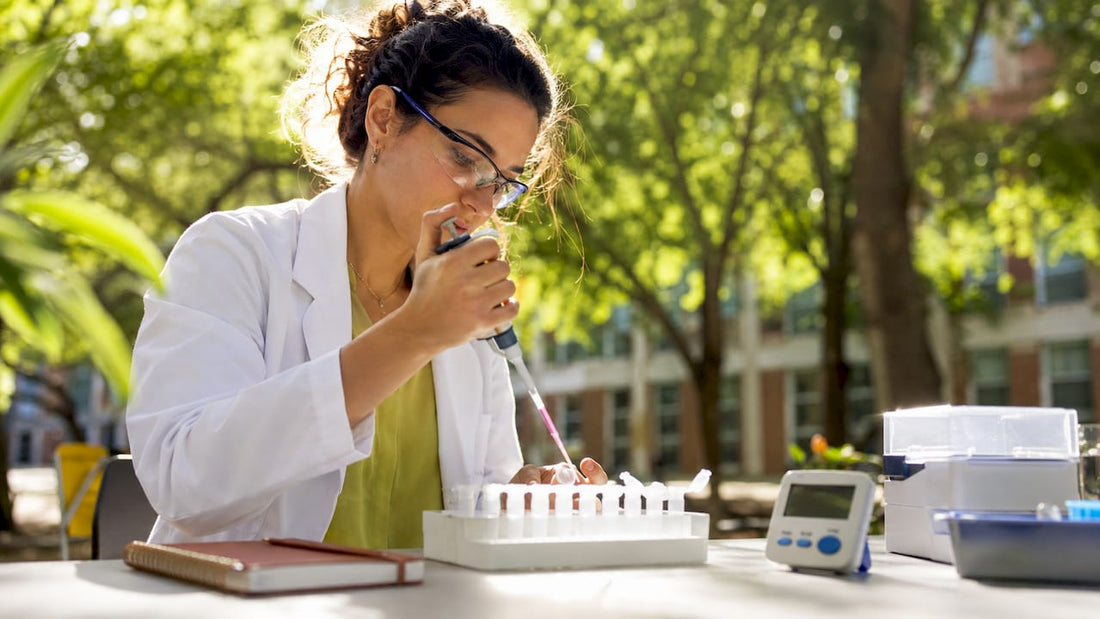 Scientist pipetting reagents in lab