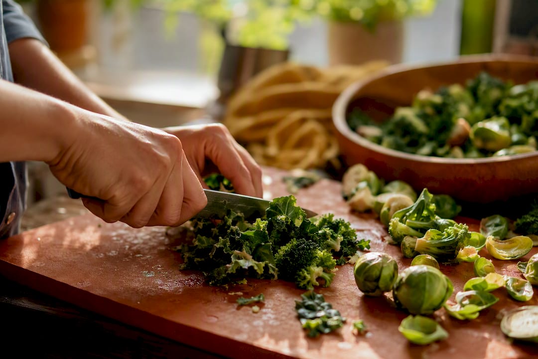 Hands chopping cruciferous vegetables